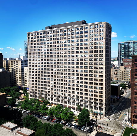 Front view of a tall, rectangular office building with numerous windows and a flat roof.