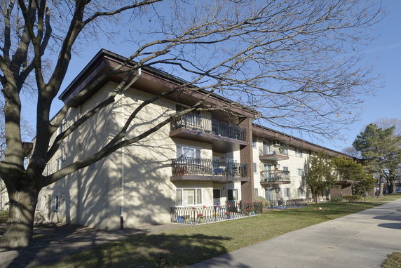 Front view of a multi-story apartment building with balconies.
