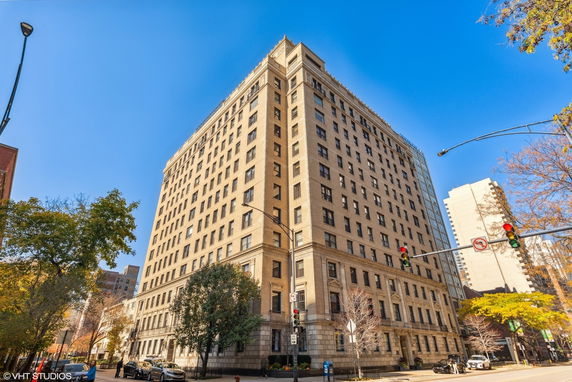 Front view of a multi-story residential building on a street corner.