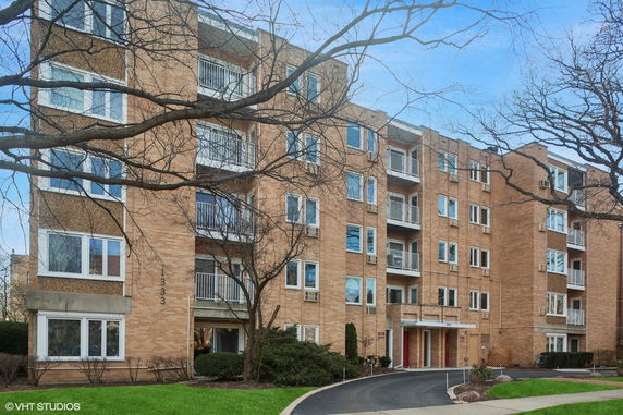Front view of a multi-story apartment building with balconies.