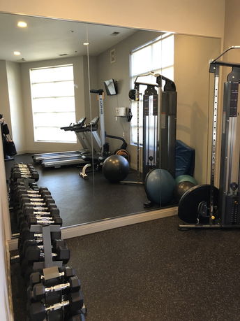 Indoor gym area with exercise equipment and mirrors.