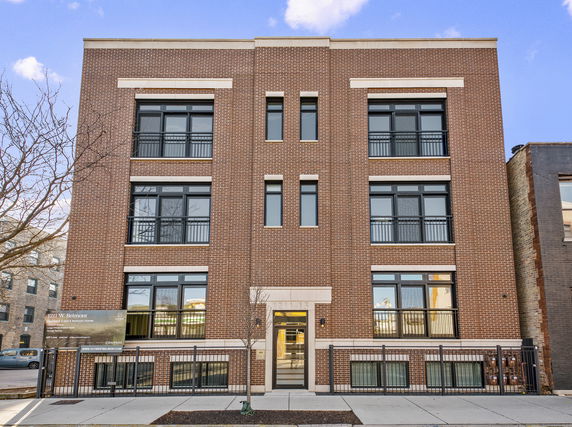 Front view of a multi-story brick apartment building.