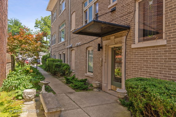 Front view of a multi-story brick building with landscaped walkway.