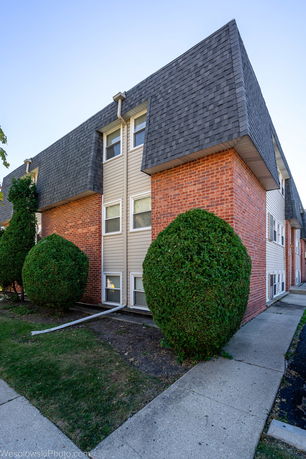 Front view of a multi-story building with brick and siding exterior.
