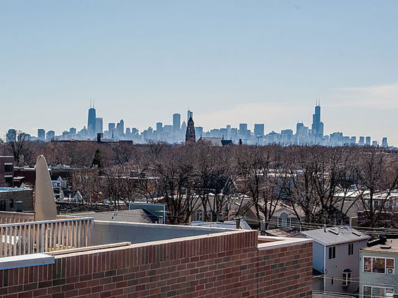 Panoramic view of a city skyline seen from a rooftop.