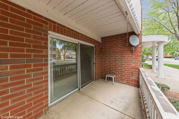 View of a brick building with a small outdoor area and a satellite dish.