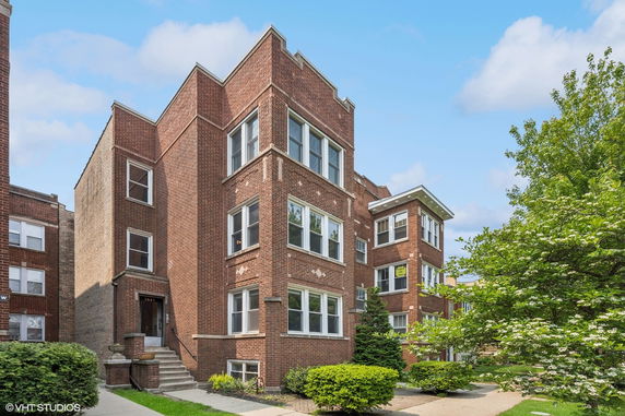 Front view of a brick apartment building with multiple windows.