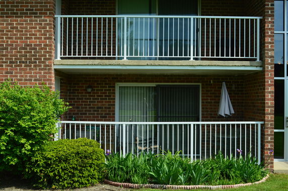 Front view of a brick apartment building with balconies.