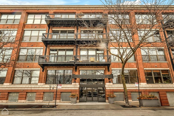 Front view of a multi-story brick building with balconies.
