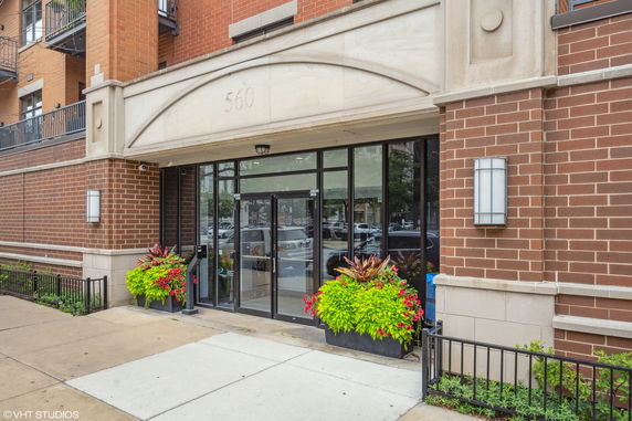 Front view of a building entrance with glass doors and brick exterior.