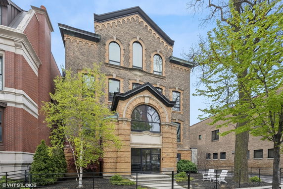 Front view of a three-story brick building with arched windows.
