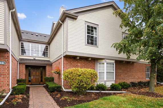 Front view of a two-story house with brick and siding exterior.