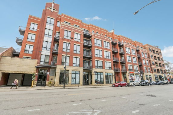 Front view of a multi-story building with large windows and balconies.