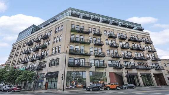 Front view of a multi-story building with balconies on each floor.
