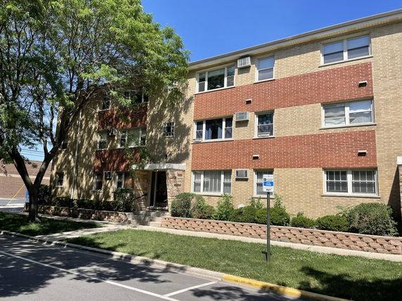 Front view of a multi-story brick apartment building.