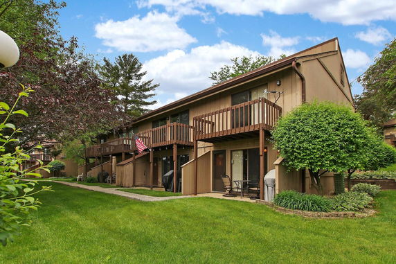 Front view of a two-story building with wooden balconies and a sloped roof.