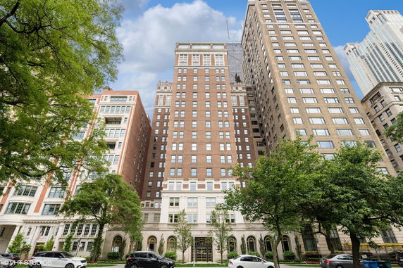 Front view of a multi-story brick building with large windows.
