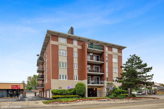 Front view of a multi-story apartment building with balconies.