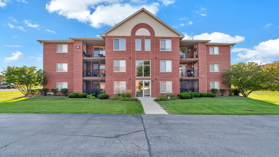 Front view of a multi-story brick apartment building.