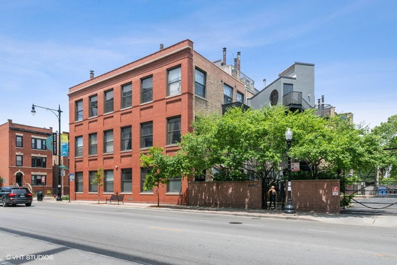 Front view of a multi-story brick building on a city street.