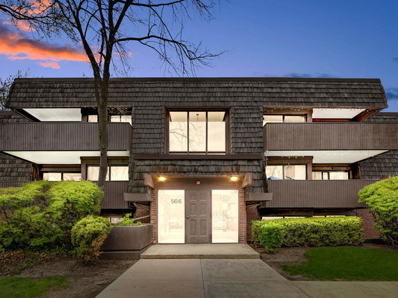 Front view of a multi-story building with unique shingle design and balconies.