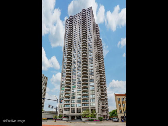 Front view of a high-rise residential building with multiple balconies.
