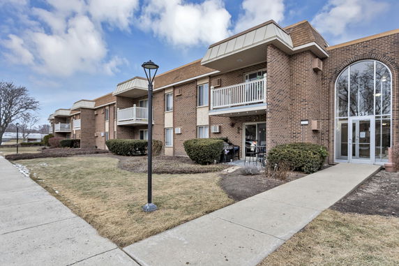 Front view of a two-story brick apartment building with balconies.