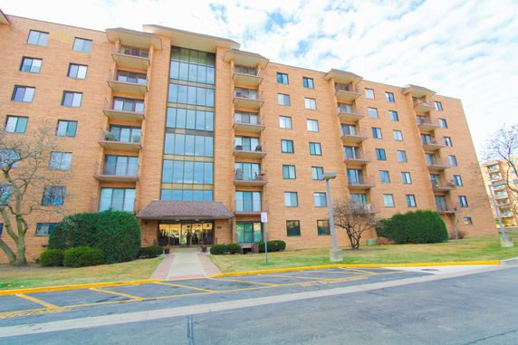 Front view of a multi-story apartment building with balconies.
