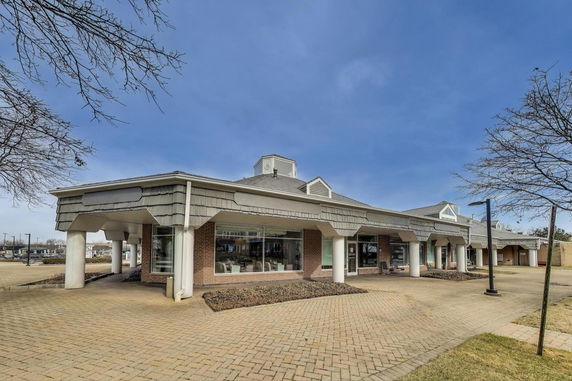 Front view of a single-story commercial building with large windows and a central dome feature.
