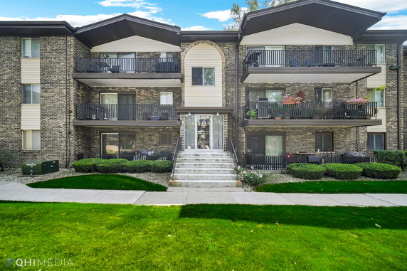 Front view of a multi-story apartment building with balconies.