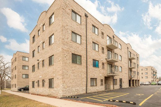Front view of a multi-story brick apartment building.