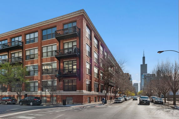 Front view of a multi-story brick apartment building with balconies.