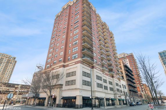 Front view of a high-rise residential building with multiple balconies.