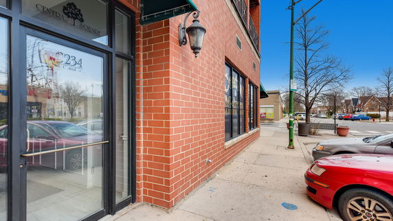 Front view of a commercial building with brick facade and glass entrance.