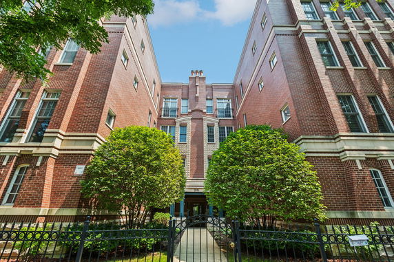 Front view of a multi-story brick building with large windows.
