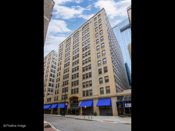 Front view of a multi-story commercial building with blue awnings.