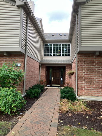 Front view of a house with a brick walkway leading to the entrance.