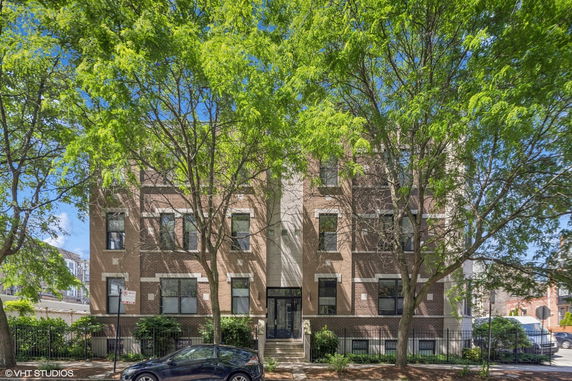 Front view of a multi-story apartment building with brick facade.