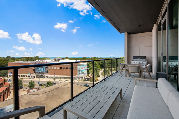 Panoramic view from a balcony overlooking a museum and park with a clear blue sky.