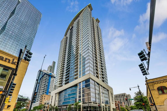Front view of a modern high-rise building with glass and concrete facade.
