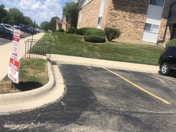 Outdoor parking area next to a multi-story brick building