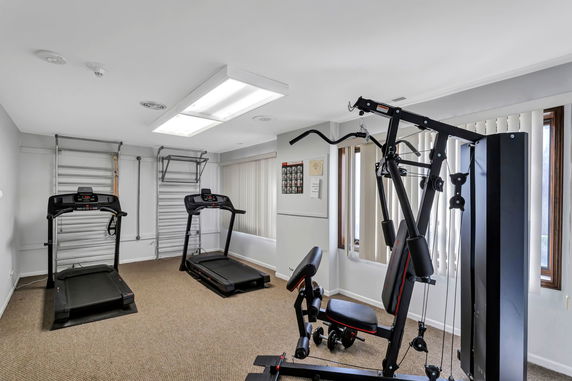 Indoor gym area with exercise equipment including treadmills and a multi-gym machine.