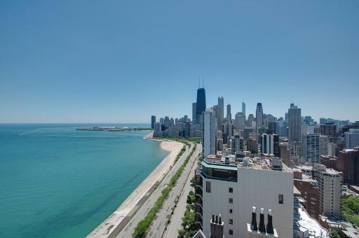 Skyline view of a city with tall buildings and a large body of water in the foreground.