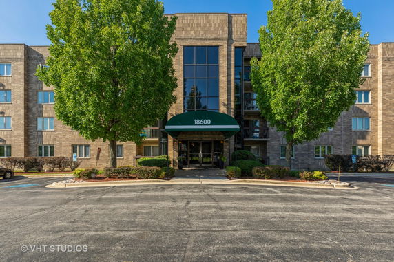 Front view of a multi-story building with a central entrance and awning.