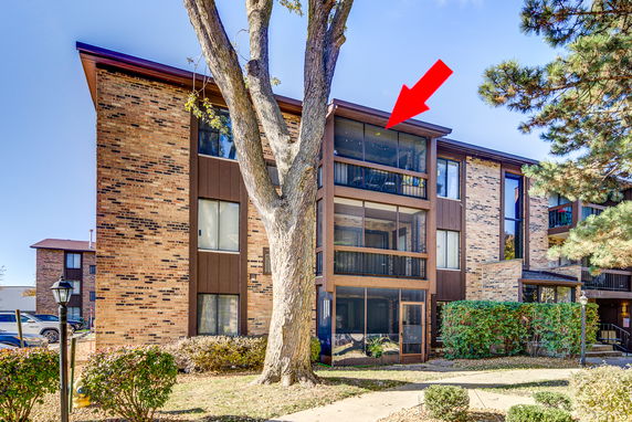 Front view of a multi-story brick building with balconies.