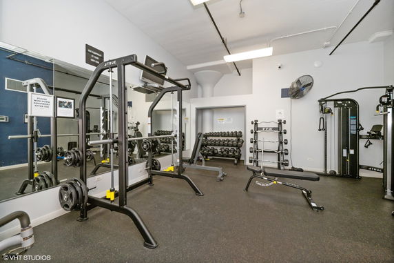 Interior view of a gym with workout equipment and weights.