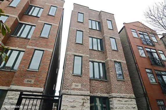 Front view of a multi-story brick building with multiple windows.