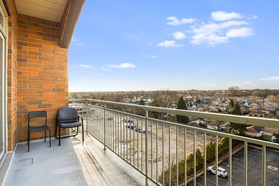 Balcony view overlooking a residential area with clear sky.