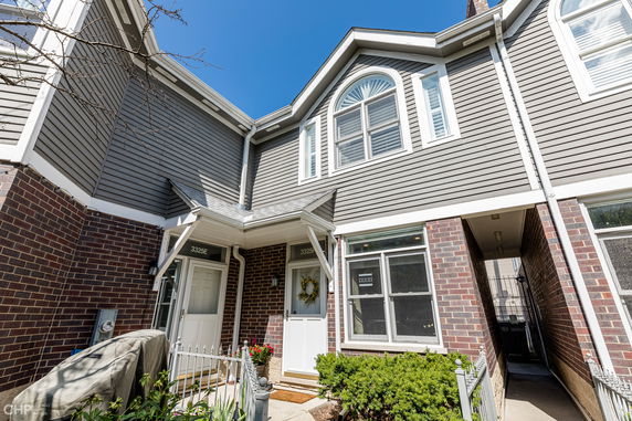 Front view of a two-story townhouse with brick and siding exterior.