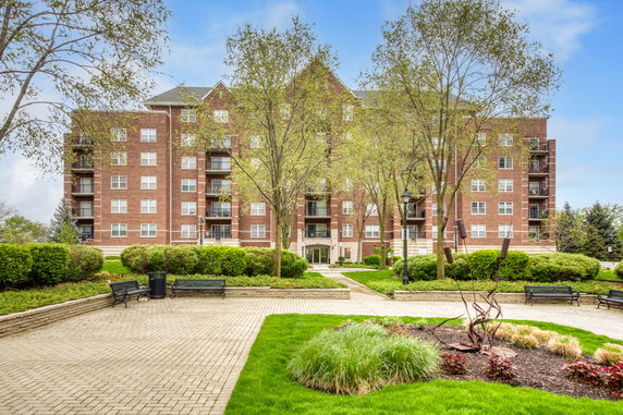 Front view of a multi-story brick residential building with balconies.